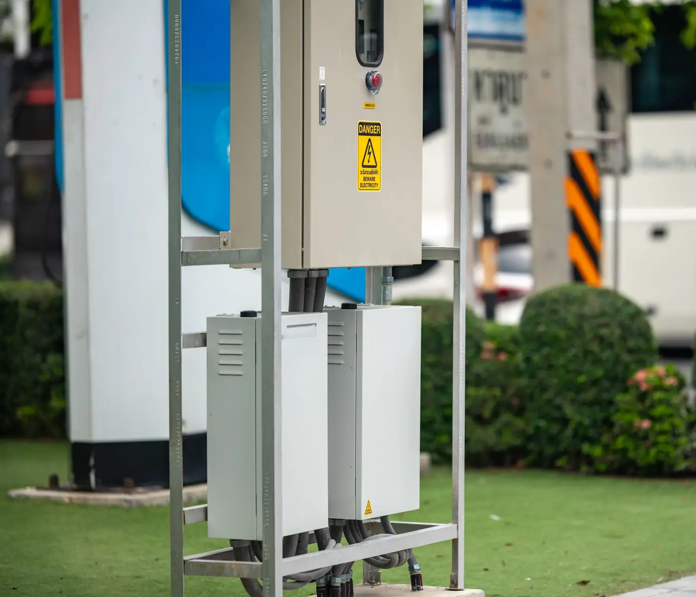 A public electric vehicle charging point and its cabinet on a city street.