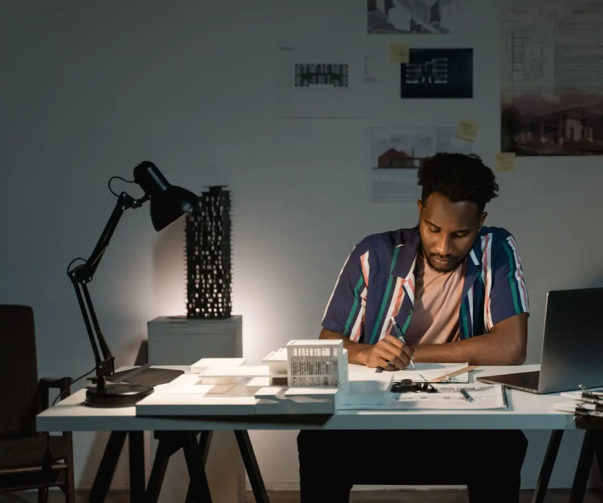 A designer working late at a drawing board.